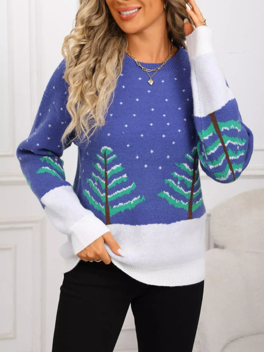 Blue acrylic sweater with evergreen trees and snow pattern, color block sleeves.