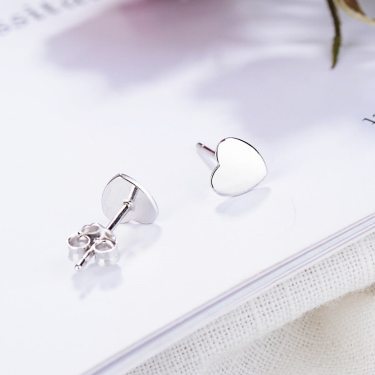 Elegant heart-shaped sterling silver stud earrings with butterfly backs