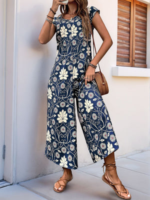 Botanical print culotte jumpsuit in navy with cap sleeves and wide legs.
