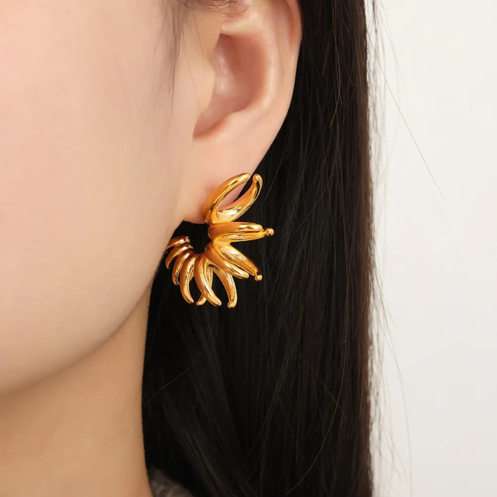 Gold sculptural petal drop earrings with a unique spiral design.