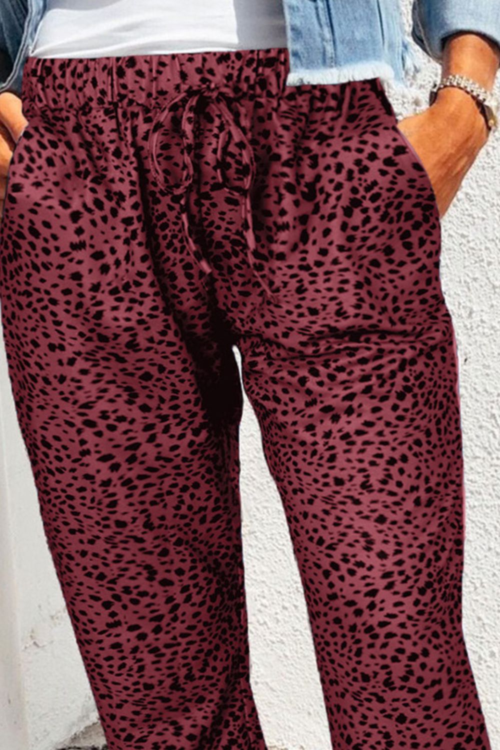 Wine leopard print drawstring trousers with relaxed fit and pockets.