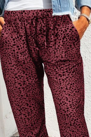 Wine leopard print drawstring trousers with relaxed fit and pockets.