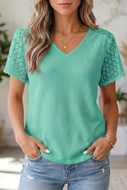 Mint green waffle knit V-neck shirt with lace short sleeves and scalloped trim.