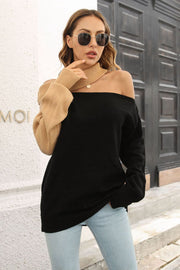 Black and camel asymmetric shoulder-baring knit sweater with cut-out neckline.