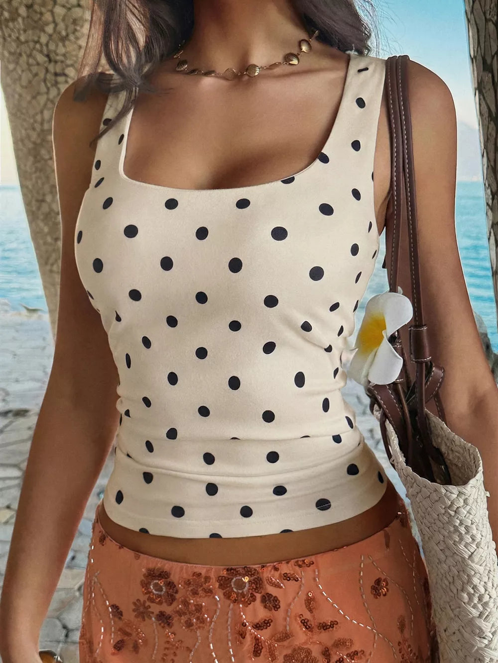 Chic polka dot tank top with scoop neck in apricot, fitted cropped style.
