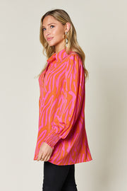 Orange and pink zebra print blouse with shirred cuffs and a collared neckline.