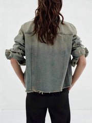Distressed light wash denim trucker jacket with frayed hem and cuffs.