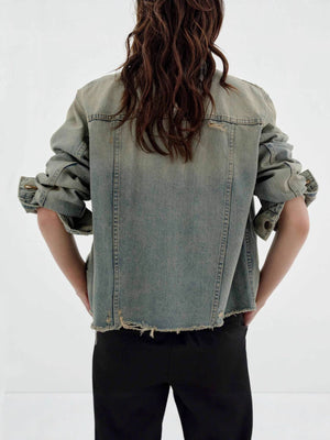 Distressed light wash denim trucker jacket with frayed hem and cuffs.