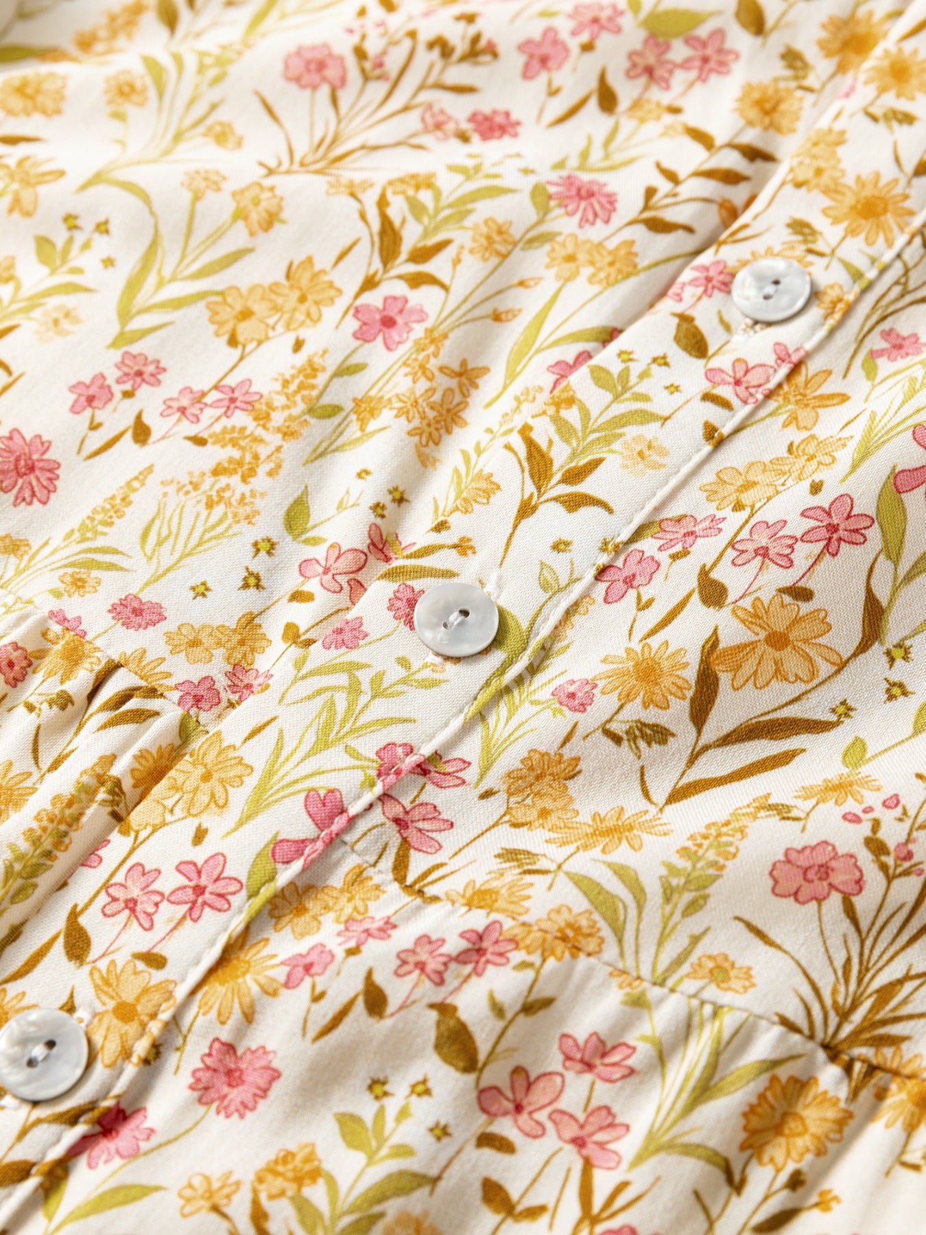 Floral print button-down shirt dress with pink and yellow flowers on a white background.