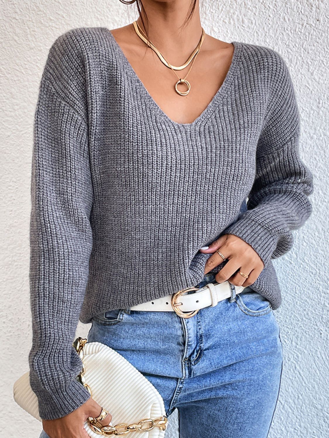 Gray ribbed knit sweater with V-neck and long sleeves, featuring a lace back detail.