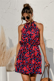 Halter neckline floral mini dress in navy with red and blue blossoms, cinched waist, and flared skirt.