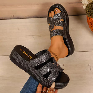 Black glitter platform sandals with open toe and crisscross straps.