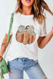 White t-shirt with a striped pumpkin graphic and a dalmatian print bow detail.