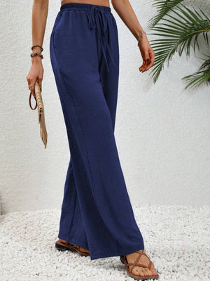 Textured dark blue palazzo trousers with drawstring waist and wide legs.
