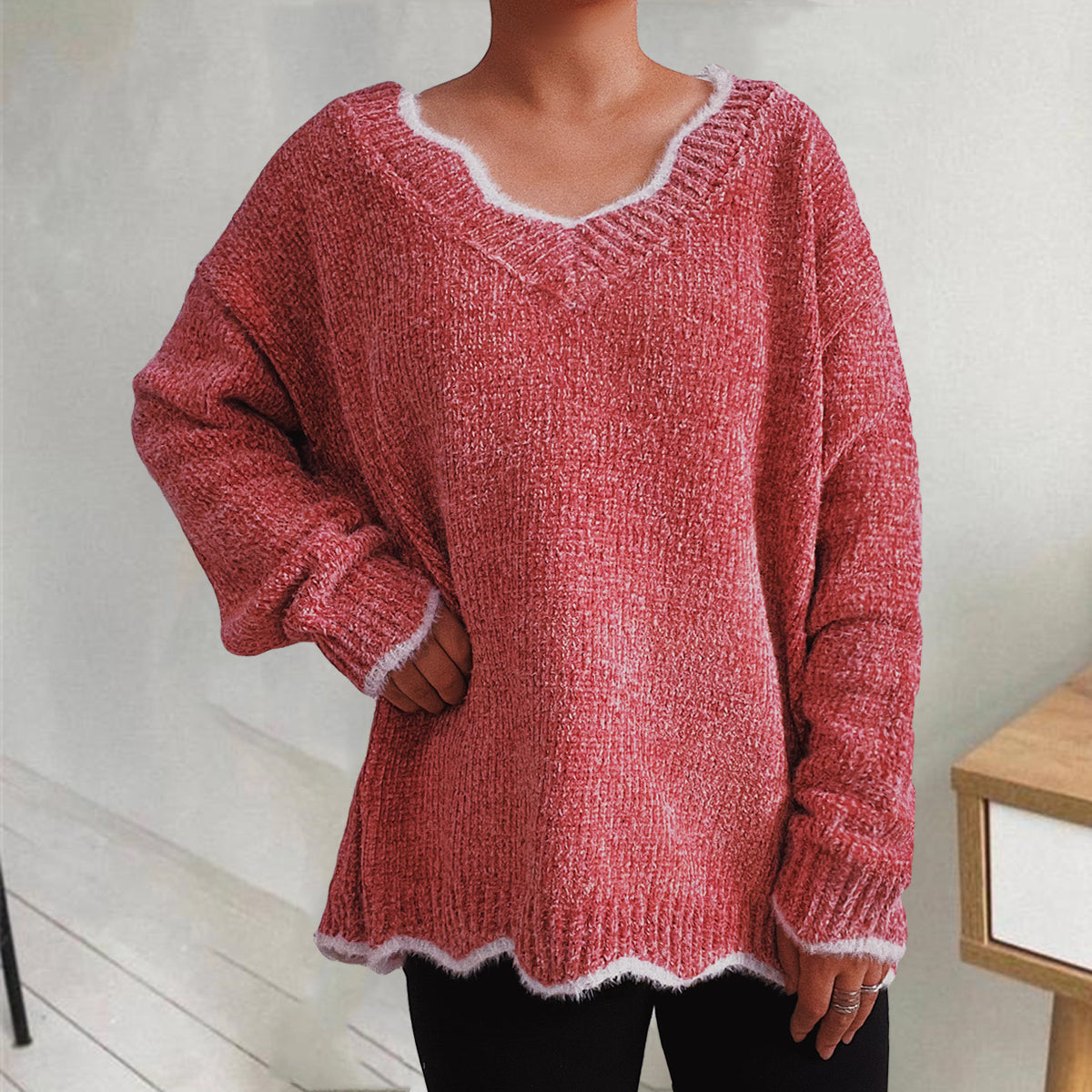 Coral knit sweater with scalloped trim and V-neck.