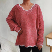 Coral knit sweater with scalloped trim and V-neck.