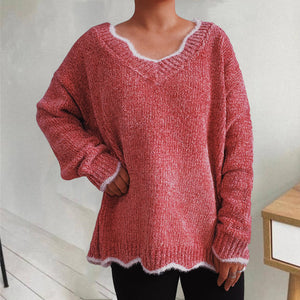 Coral knit sweater with scalloped trim and V-neck.