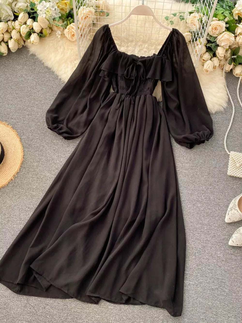Black A-line maternity dress with square neck, ruffled detail, tie front, and balloon sleeves.
