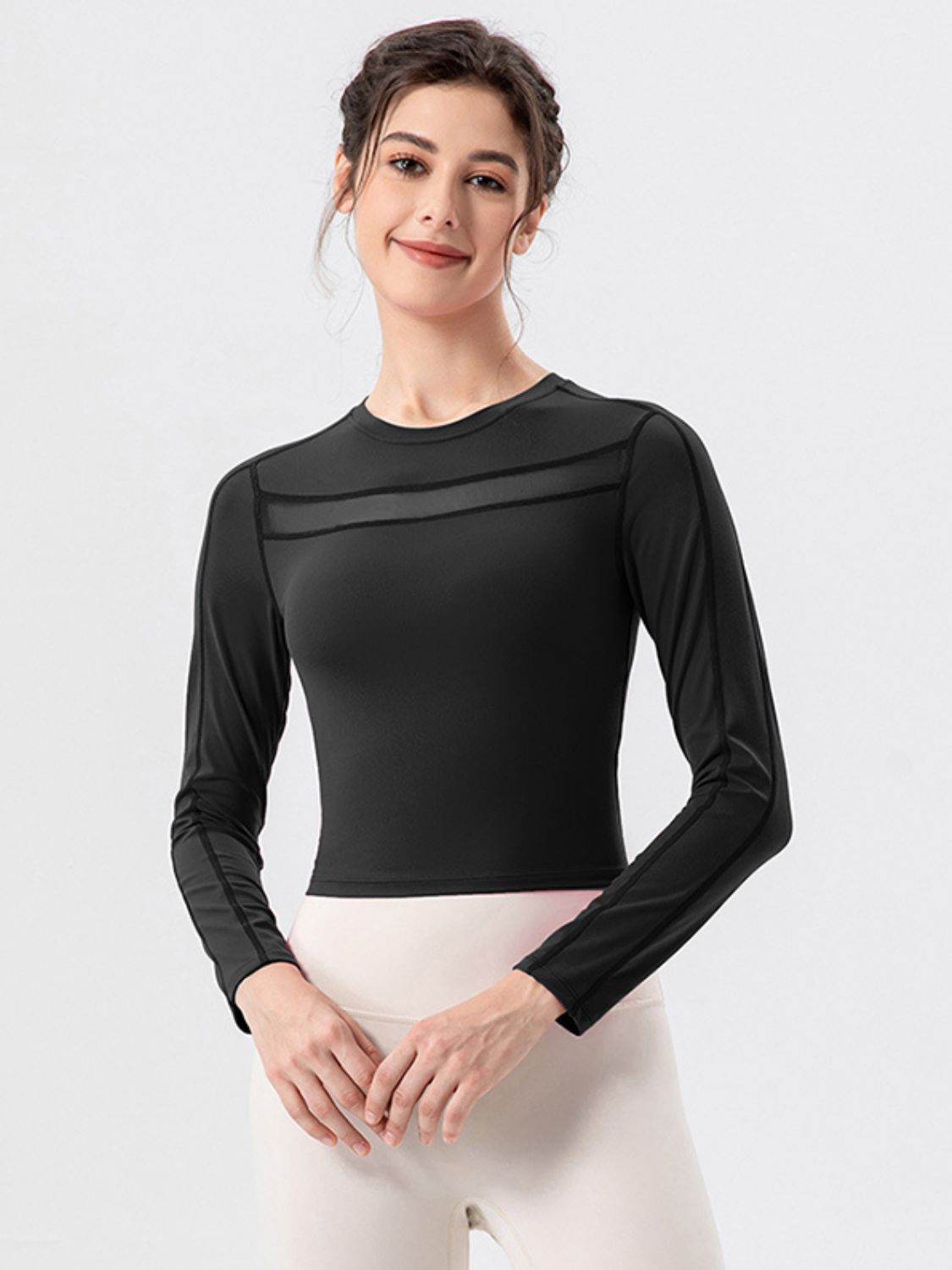 Black long sleeve crop top with mesh panel detail at neckline and sleeves.
