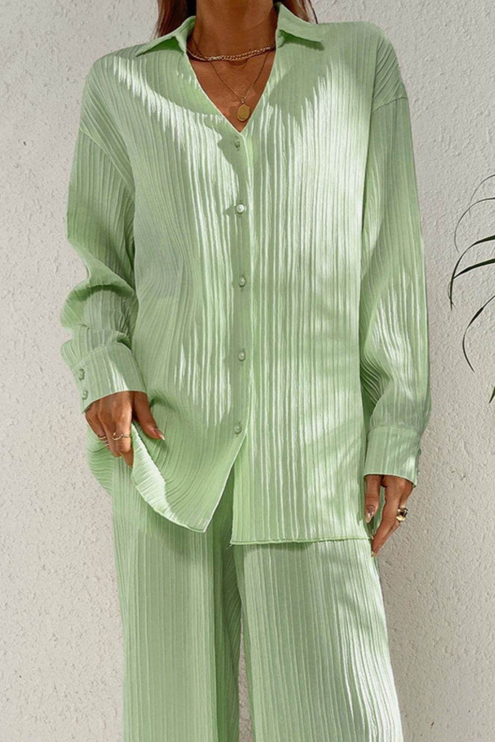 Pleated pastel blue co-ord set with button-down shirt and wide leg trousers.