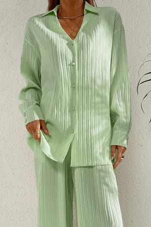 Pleated pastel blue co-ord set with button-down shirt and wide leg trousers.