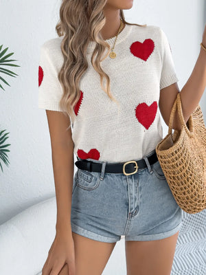 White knit t-shirt sweater with red heart pattern and short sleeves.