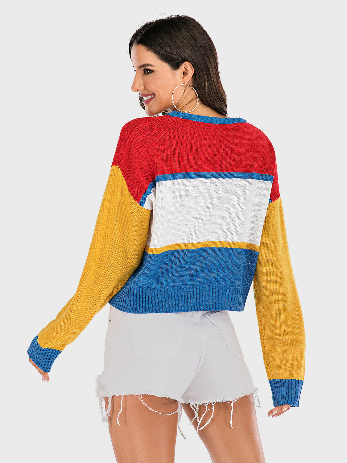 Colorblock knit sweater with crew neck and long sleeves in red, white, blue, and yellow stripes.