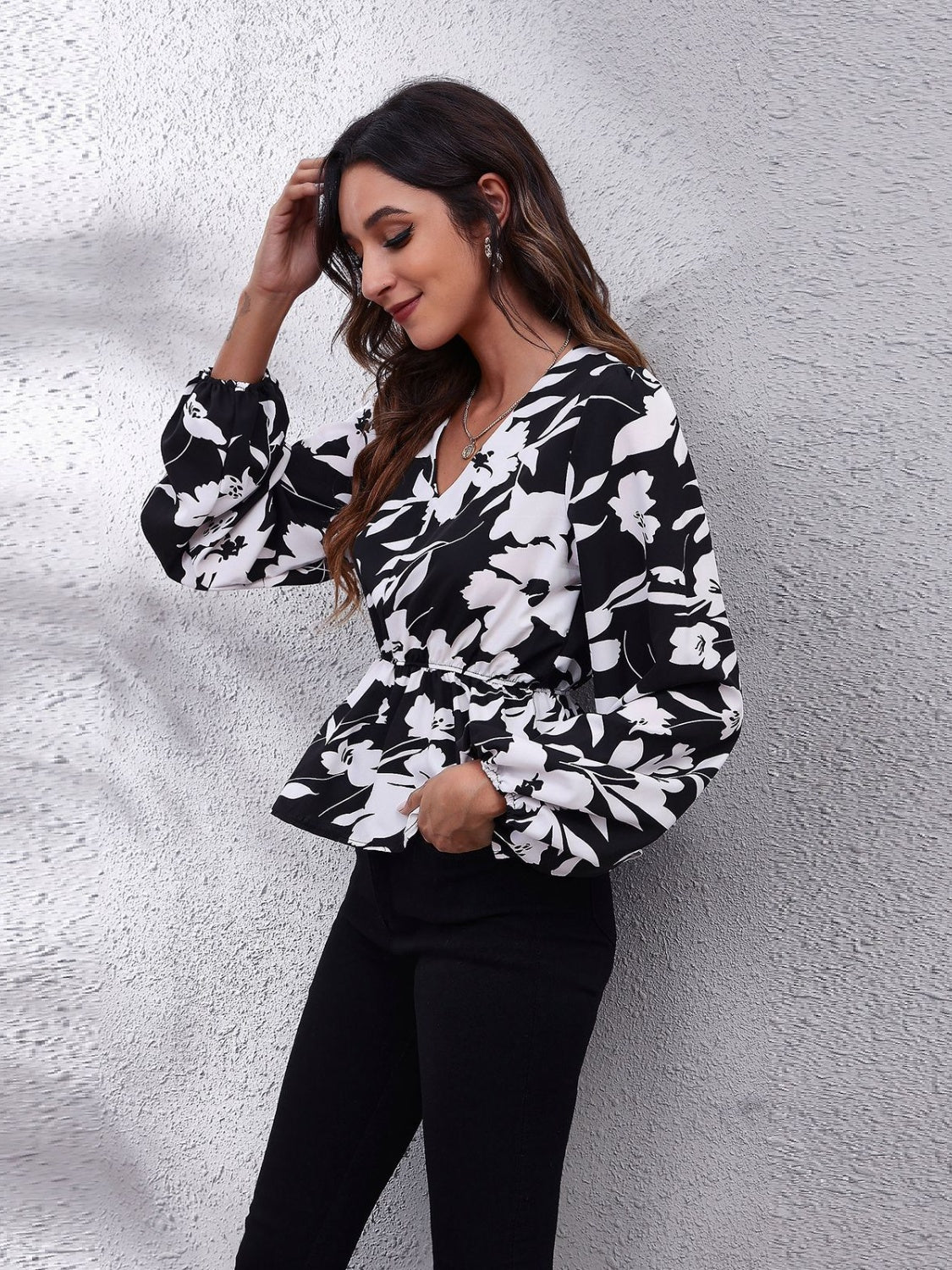 Black peplum blouse with butterfly print, gathered waist, and balloon sleeves.
