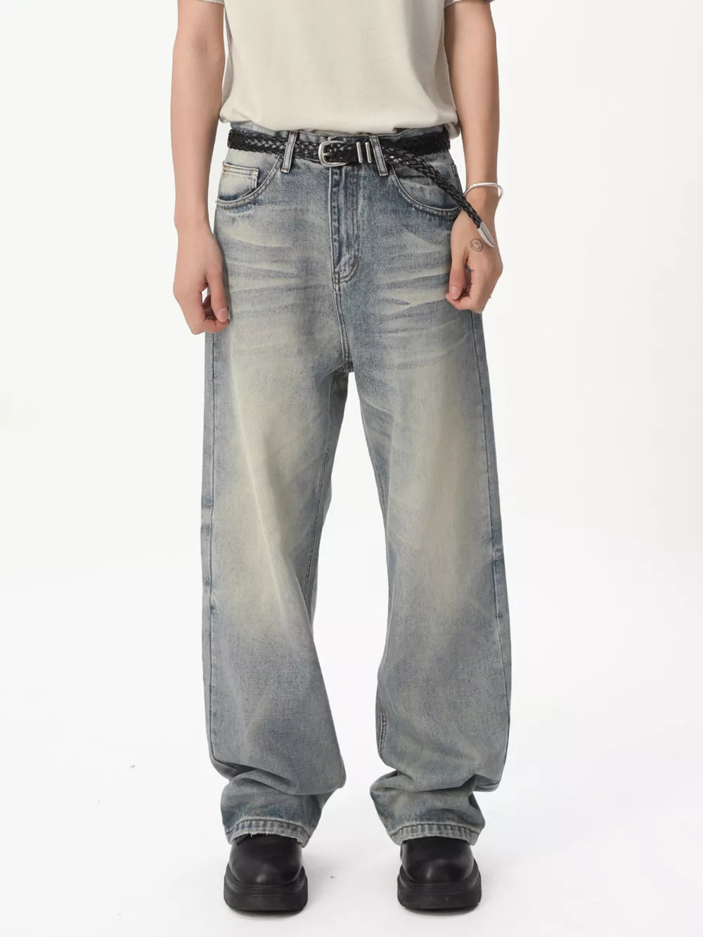 Men's light blue vintage wash wide leg jeans with a braided belt.