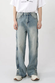 Medium wash baggy denim jeans with snap hem and side slits