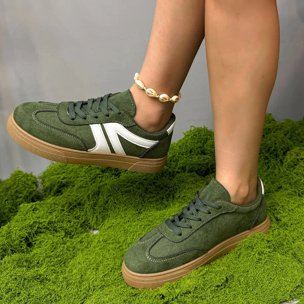 Green suede panel sneakers with white accents and gum soles.