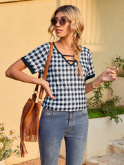 Houndstooth tunic top with cutout neckline and short sleeves, styled with jeans.