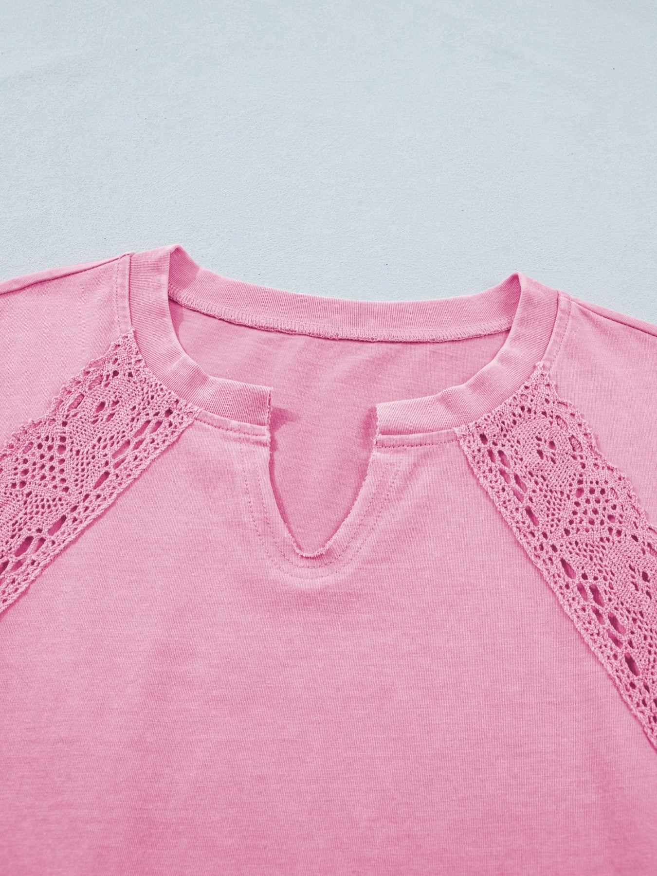 Pink mineral wash cotton tee with notched neckline and crochet lace detail.