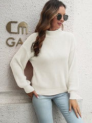 White acrylic mock neck sweater with balloon sleeves and ribbed texture.
