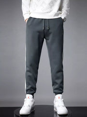 Dark gray cotton joggers for men with white side stripes and cuffed ankles.