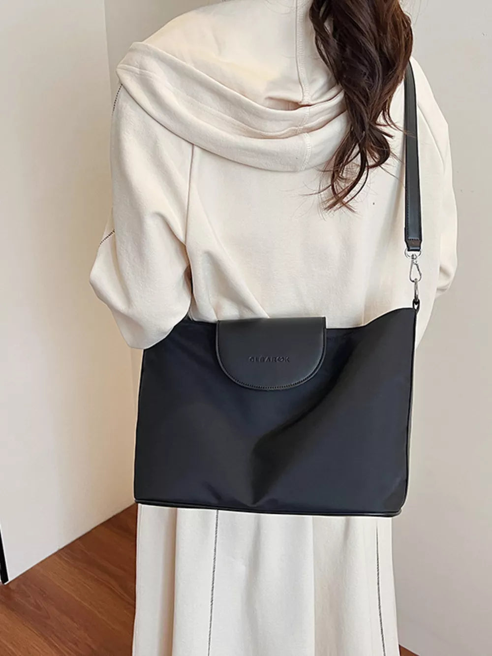 Chic canvas hobo crossbody bag in black with leather flap detail.