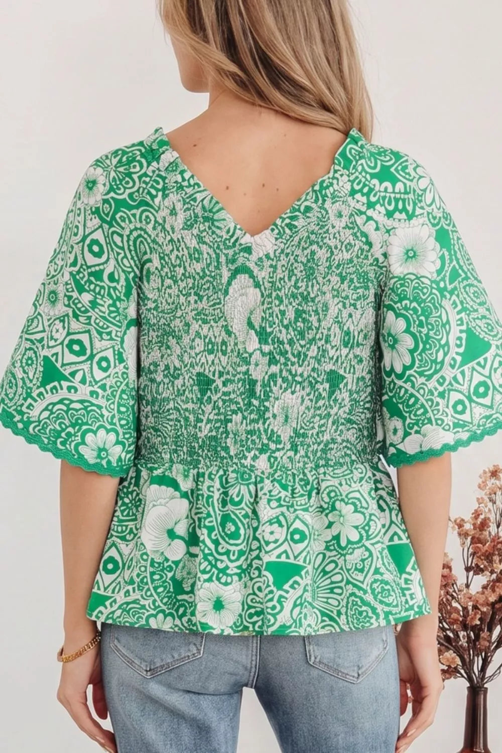 Green floral print smocked v-neck polyester overshirt with ruffled sleeves.