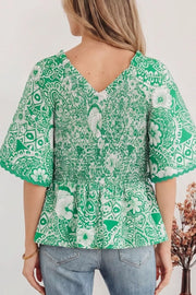 Green floral print smocked v-neck polyester overshirt with ruffled sleeves.
