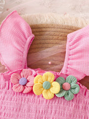 Pink smocked jumpsuit with floral appliques and ruffled sleeves