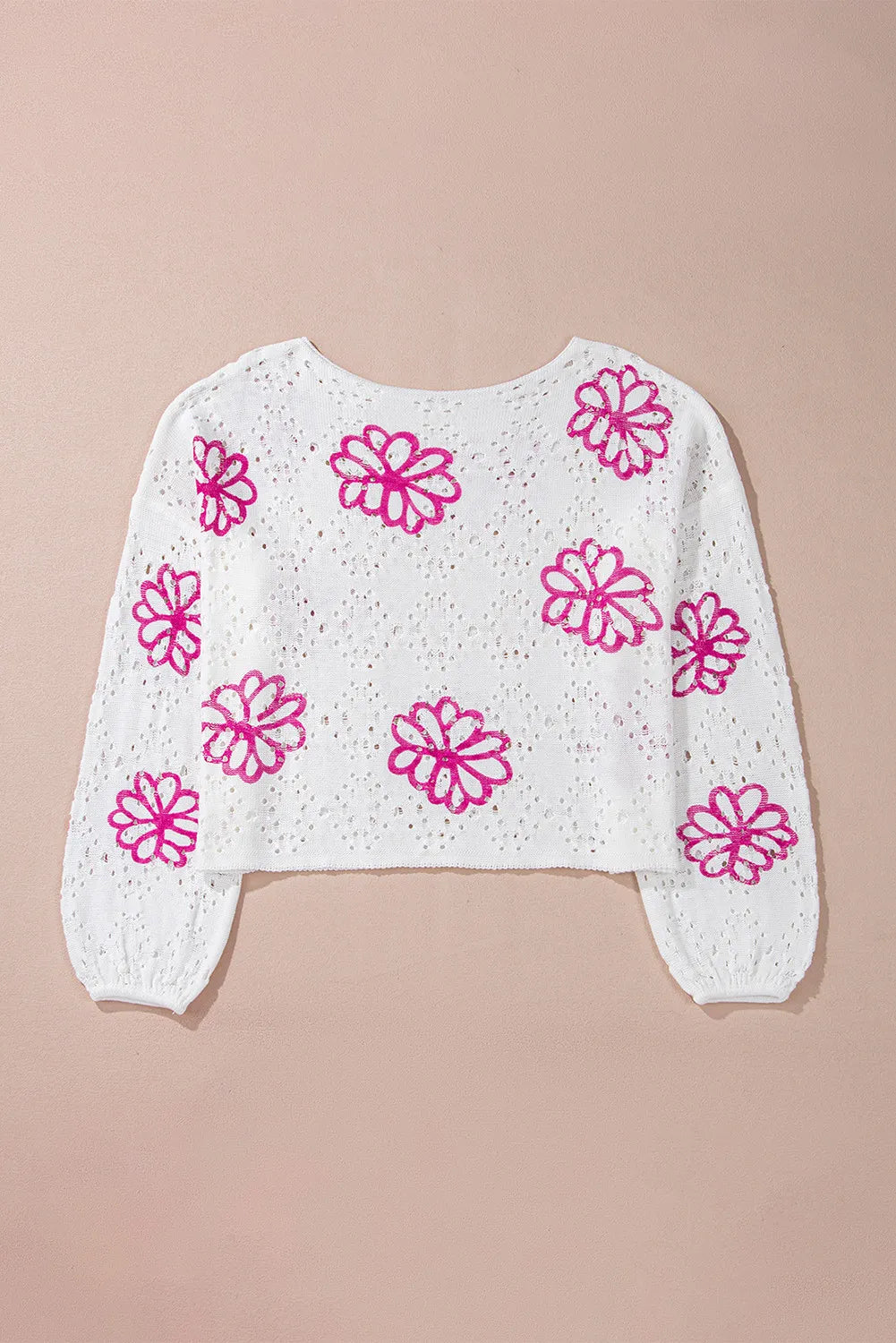 White eyelet knit pullover with floral embroidery and balloon sleeves.