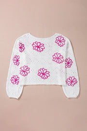 White eyelet knit pullover with floral embroidery and balloon sleeves.