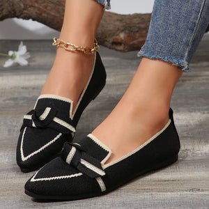Black mesh slip-on flats with cream trim and bow detail.