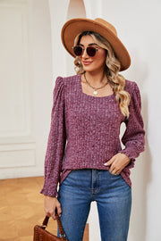 Textured square neck blouse with puff sleeves and ruffled cuffs in a deep rose color.