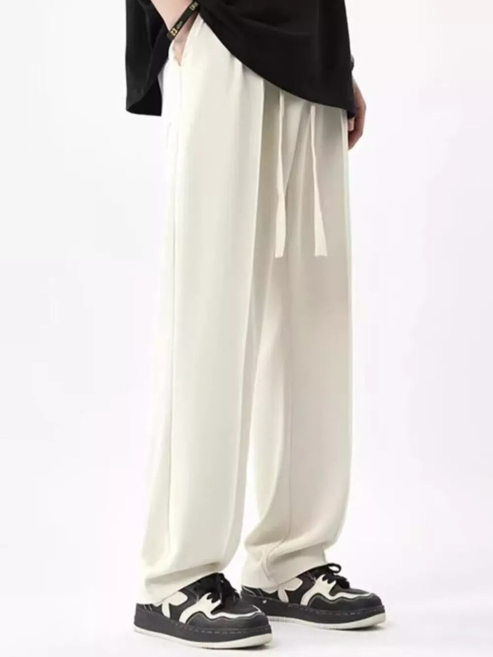 Men's ivory wide leg sweatpants with drawstring waist and pockets.
