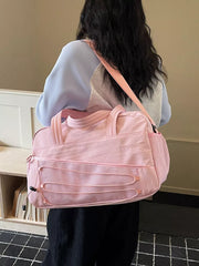 Pink nylon travel bag with bungee cord detail and adjustable strap.