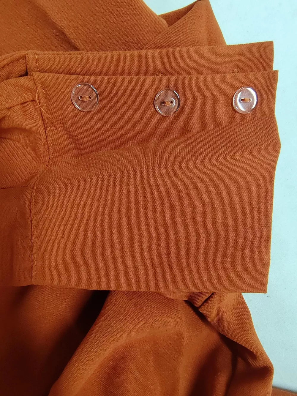 Ochre polyester two-piece set with pocket detail and clear button cuffs