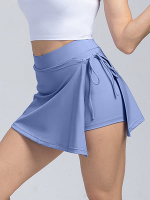Light blue skort with wrap detail and side tie, athletic shorts underneath.