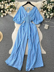 Light Blue polka dot smocked wide-leg romper with V-neck and tie back.