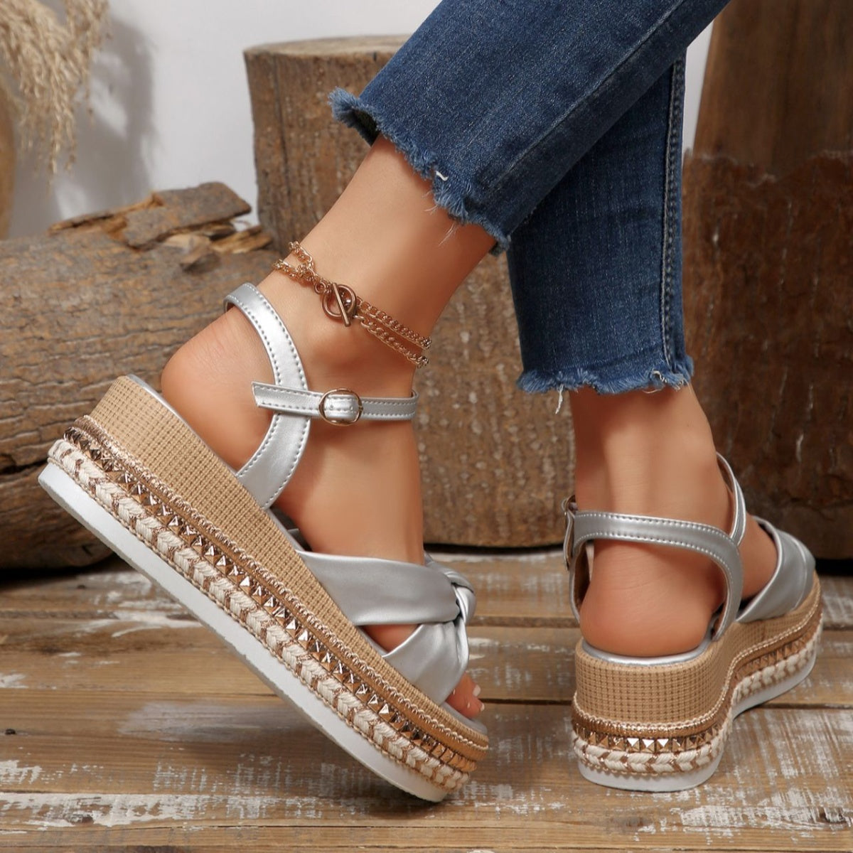 Silver bow knot wedge sandals with braided trim and ankle buckle, styled with jeans.