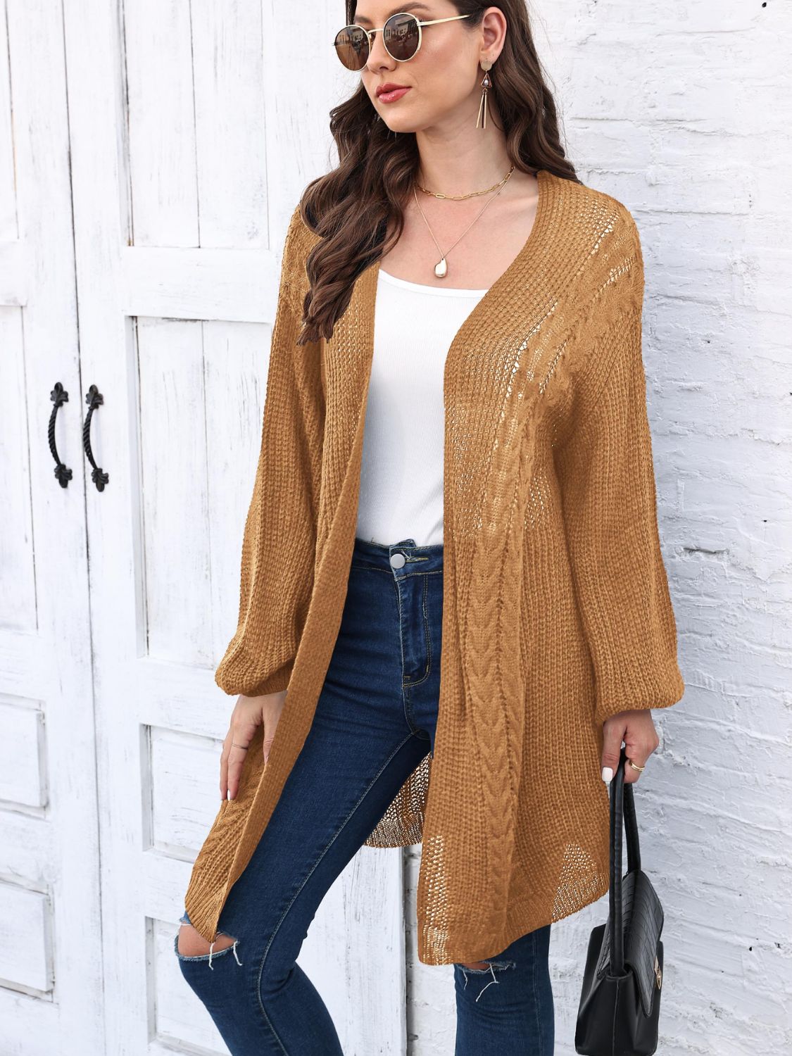Caramel cable knit cocoon cardigan with open front and long sleeves.
